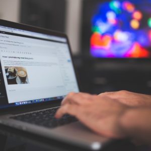 Person's hands on computer using WordPRess